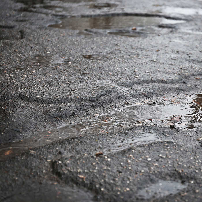 Asphalt with standing water, needs to be repaired