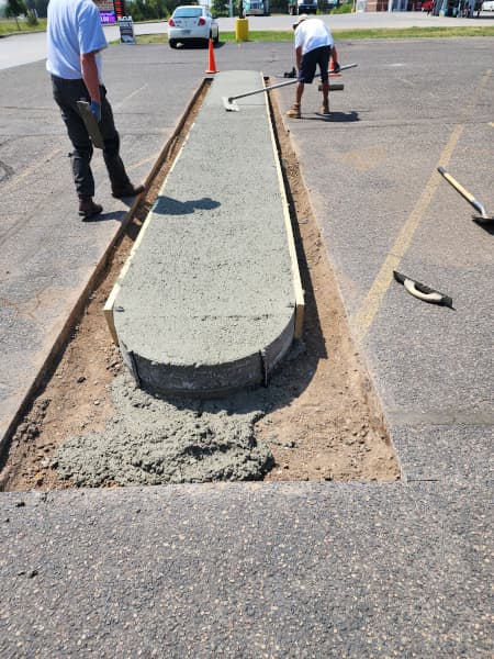 Concrete islands being installed in parking lot. 