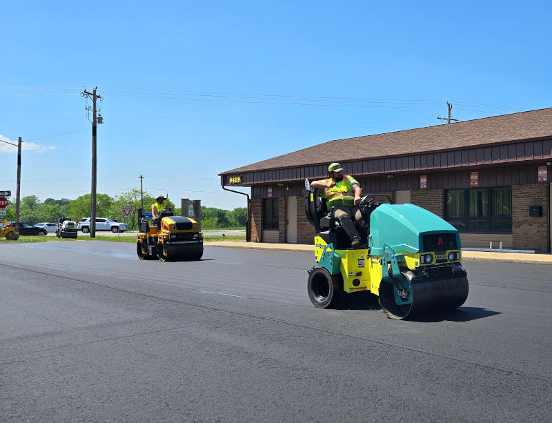 steel drum and rubber rollers compacting new asphalt