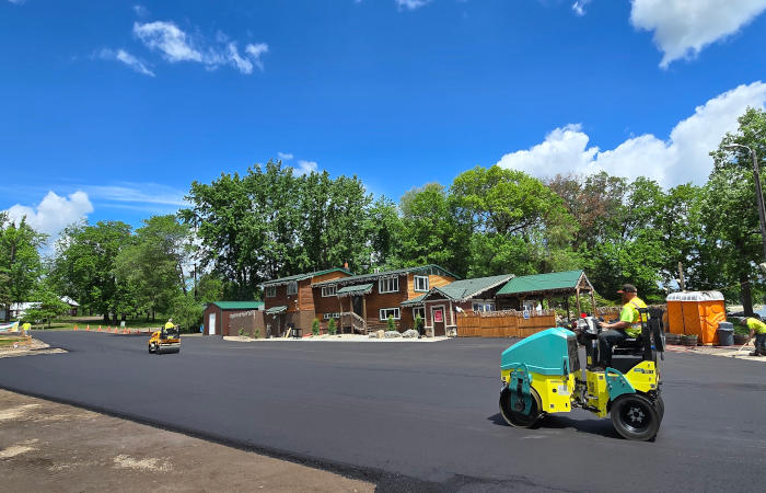 Asphalt being installed and compacted in parking lot