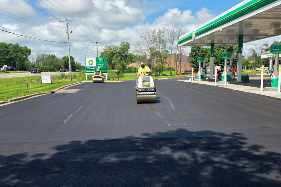 roller operator compacting new asphalt 